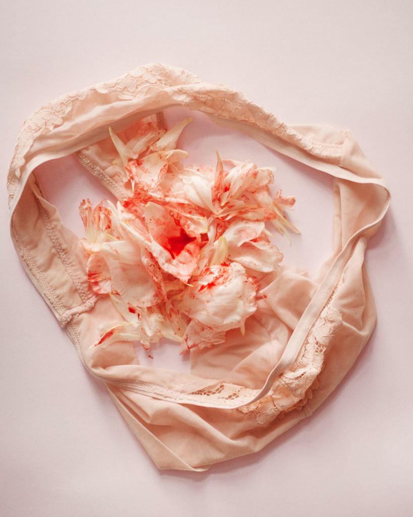 A pair of crumpled, pale pink underwear on the floor, with red splattered flowers in the gusset.
Pandora's Health Blog