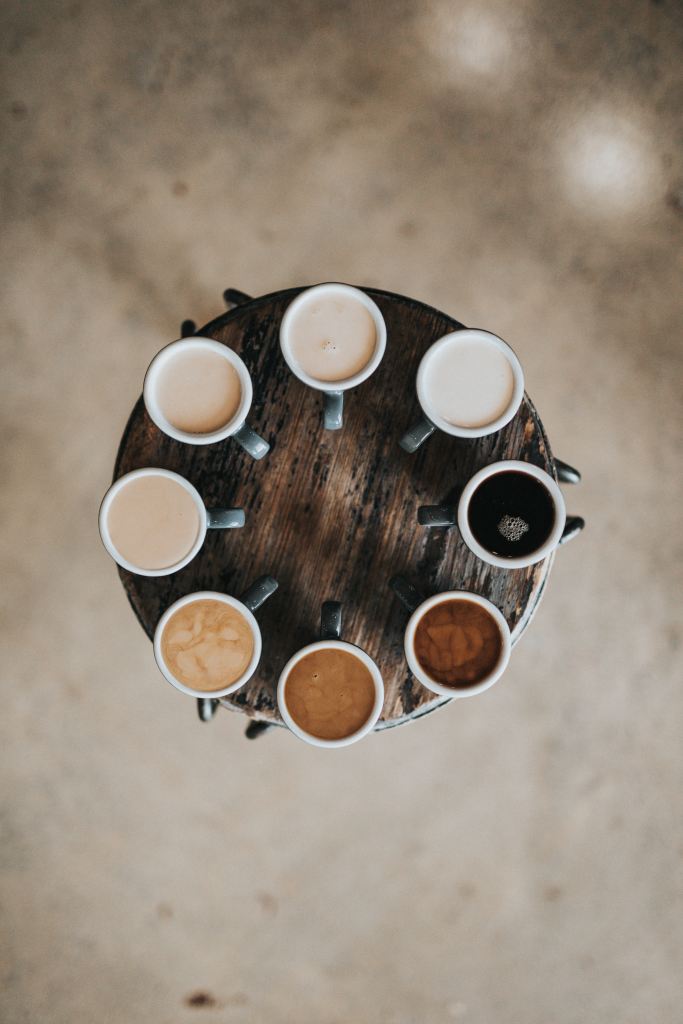 Eight cups of coffee are arranged in a circle on a round wooden table. The colours of the coffee range from almost white to black, due to the levels of milk in the drinks. 

Pandora's Health blog.

Image courtesy of Unsplash.